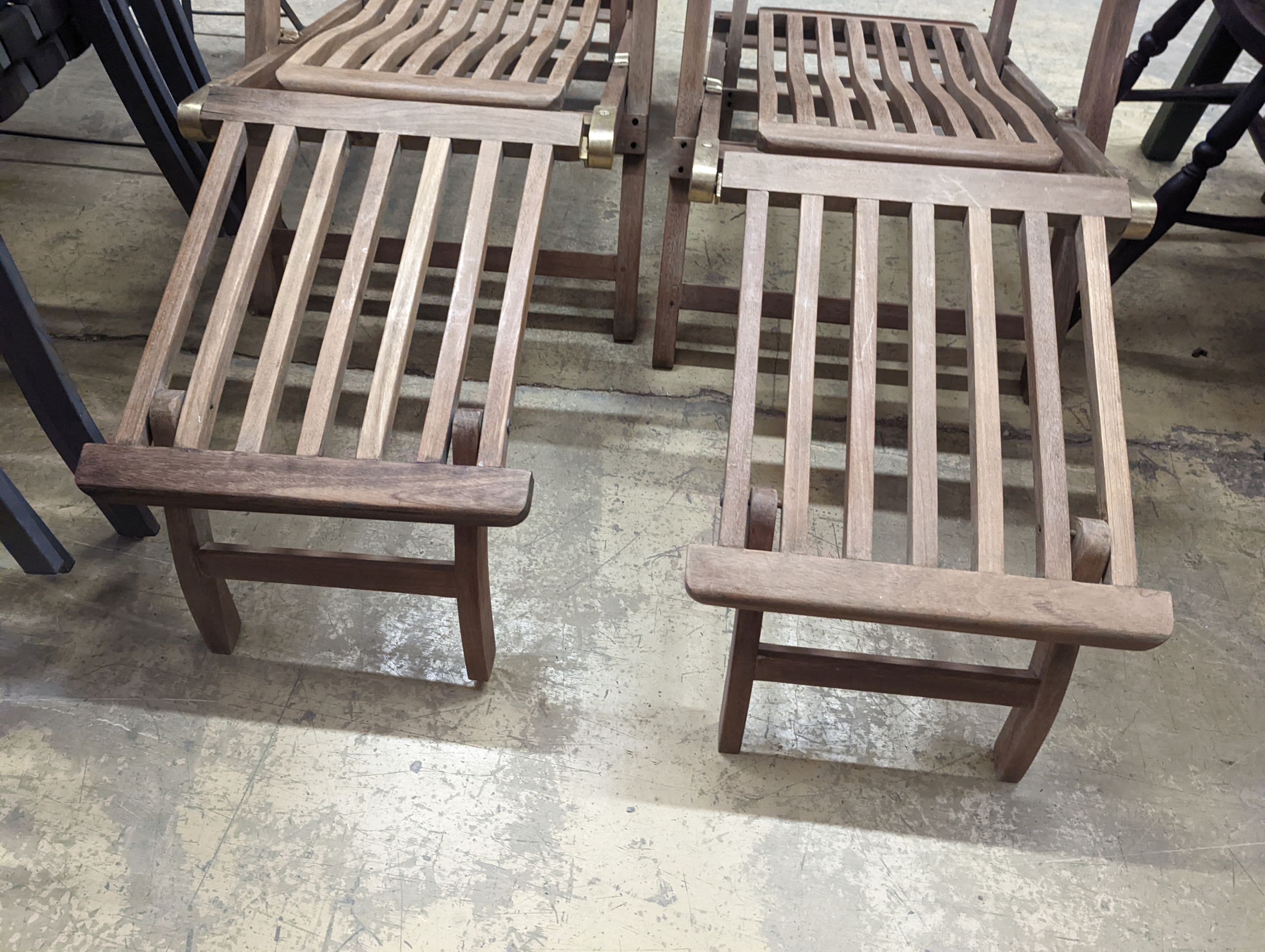 A pair of brass mounted teak garden steamer chairs, length 140cm, depth 58cm